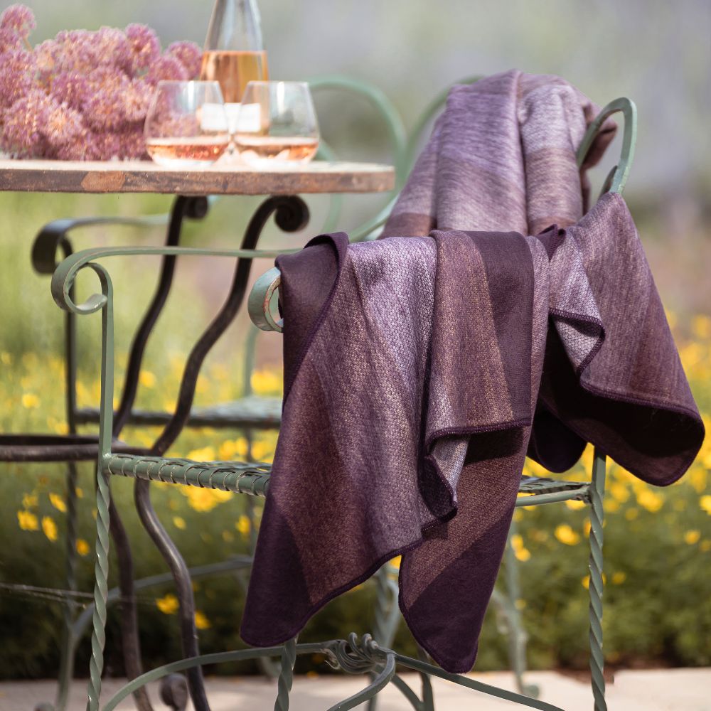 Deep purple handwoven throw blanket draped over outdoor chair