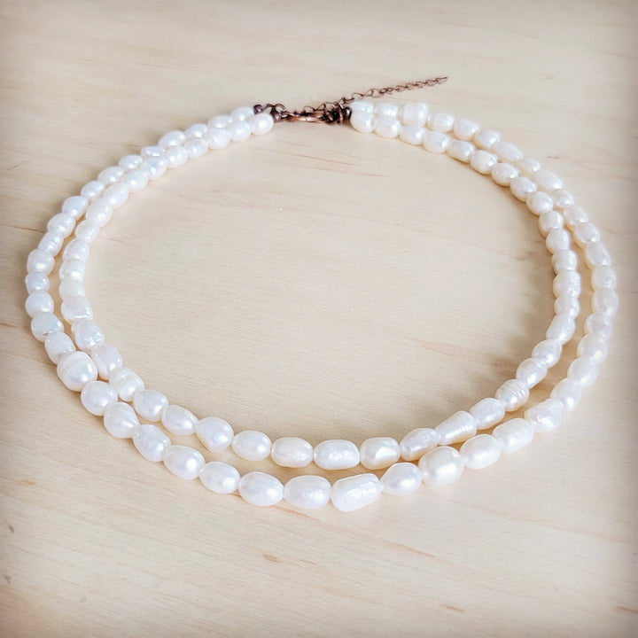 Double-strand freshwater pearl necklace with rose-tone clasp and layered oval pearls