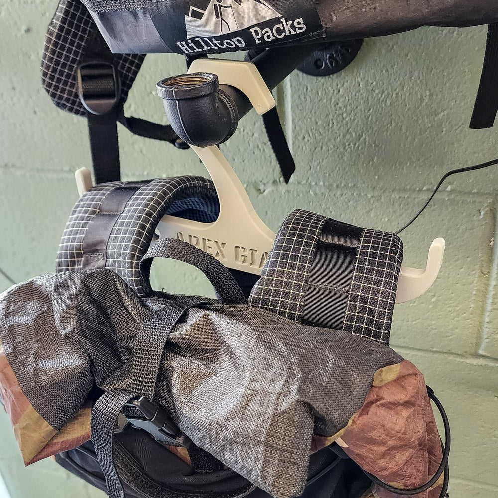 Light gray backpack hanger with curved hooks holding a backpack bag