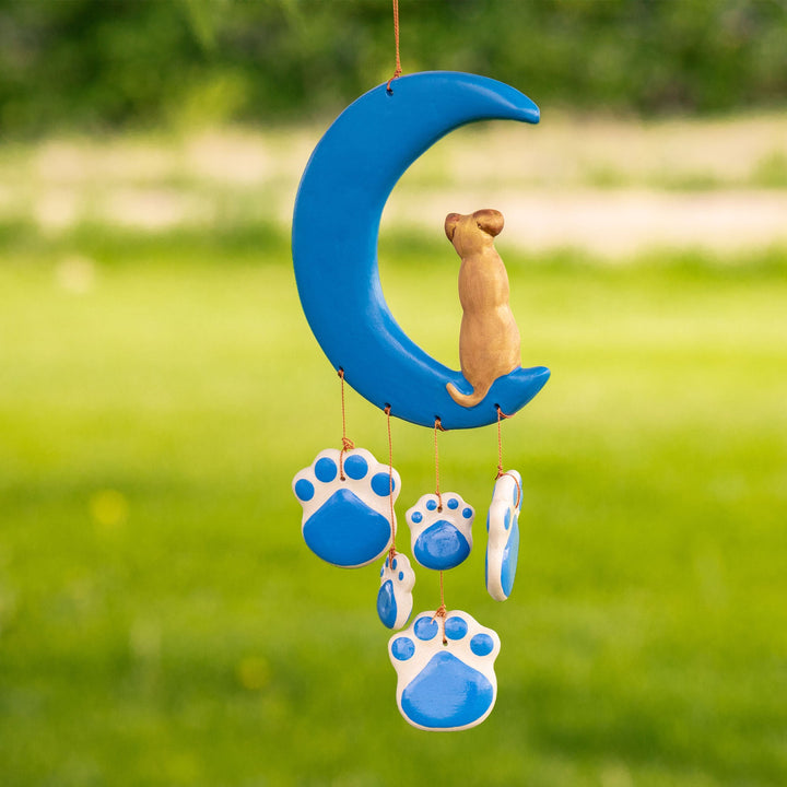 Outdoor view of blue ceramic moon wind chime with cat figure and dangling paw discs