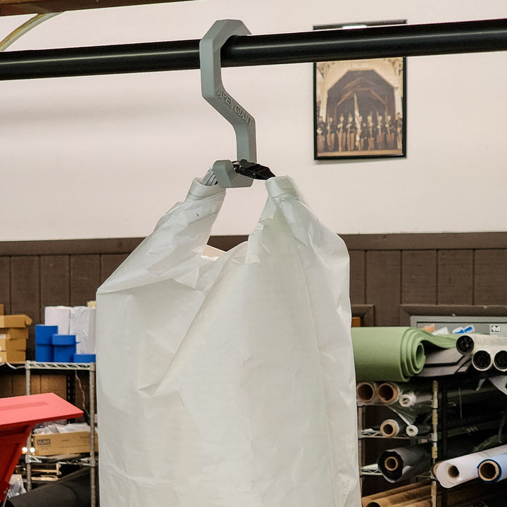 Gray gear hanger hook on a rod, with white bags hanging from it.
