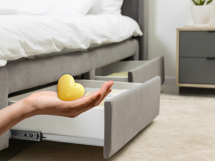 Yellow heart wax freshener held in a hand near a drawer