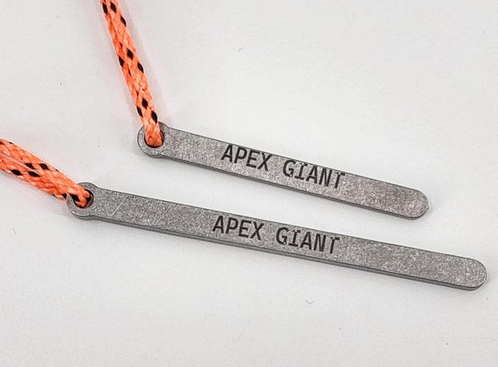 Grey bear bag toggle bars with orange braided cord loops, close-up
