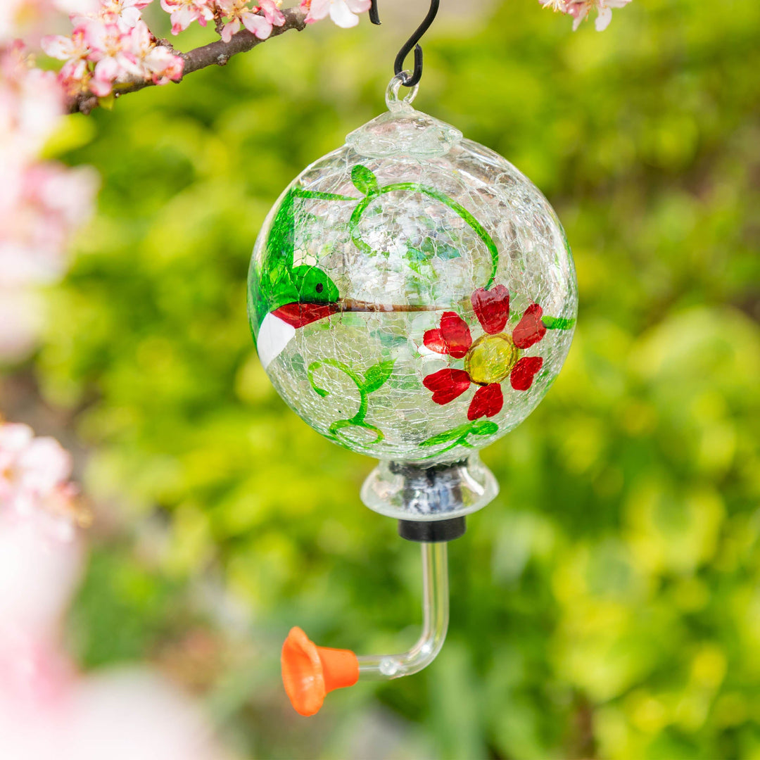 Hand-painted glass hummingbird feeder with green vines and red flower accents