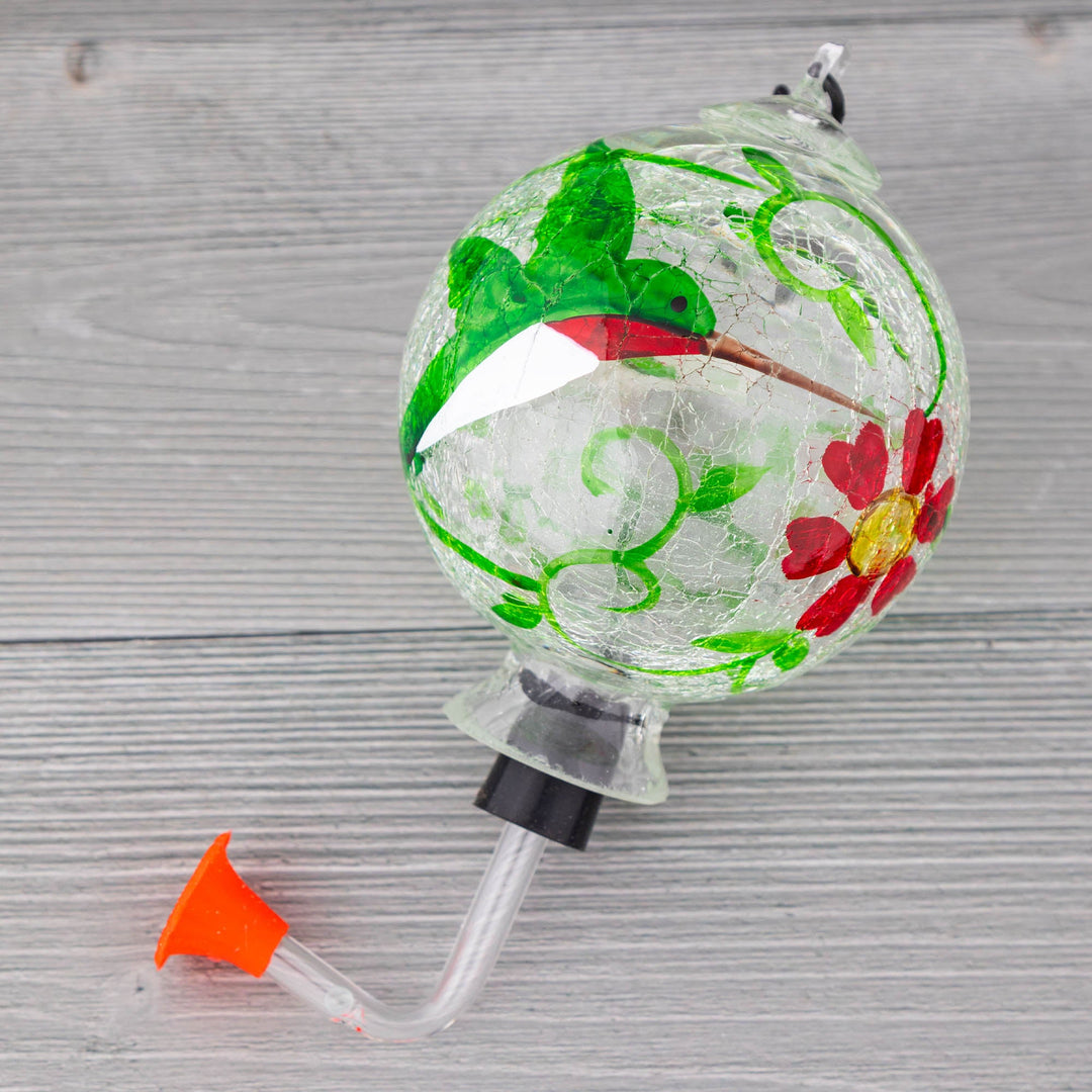 Hand-painted glass hummingbird feeder with green bird and red flower accents