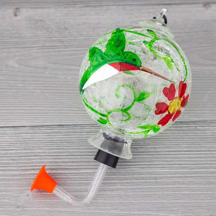 Hand-painted glass hummingbird feeder with green bird and red flower accents