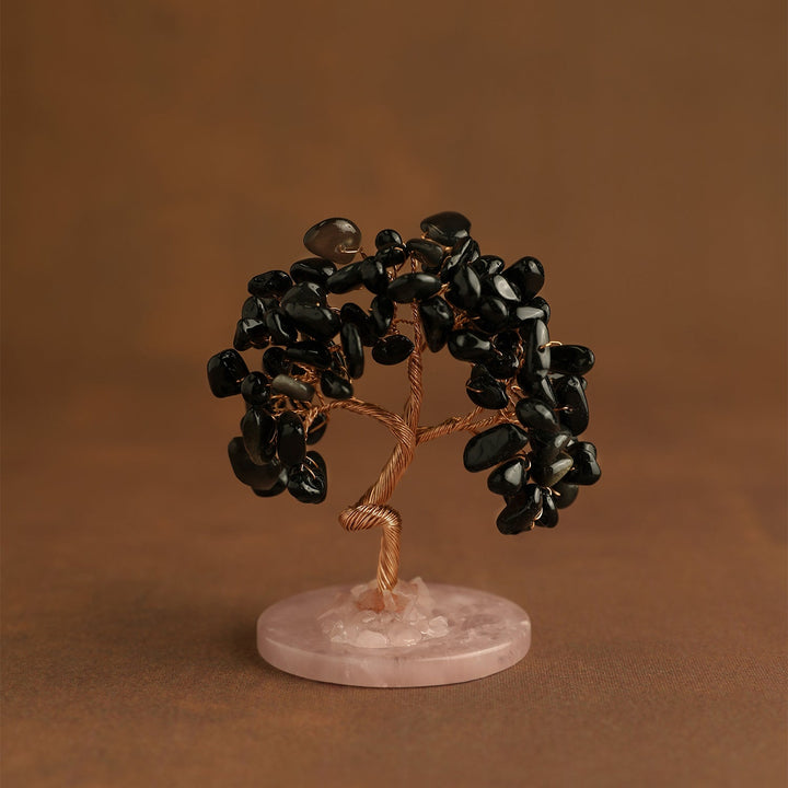 Mini crystal tree with dark black gemstones on pink stone base