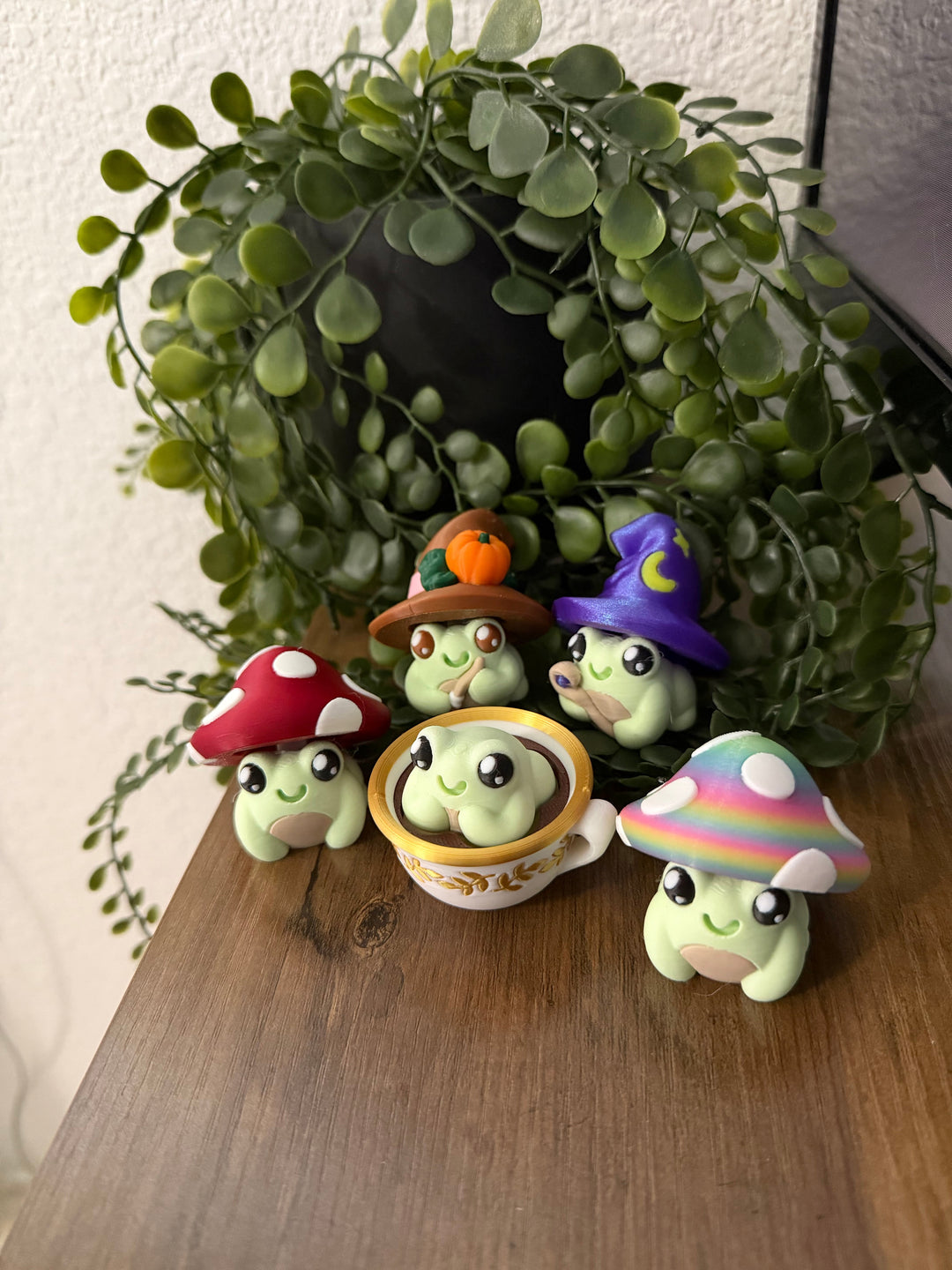 Frog toy with mushroom hat, holding clicker, green face and painted details