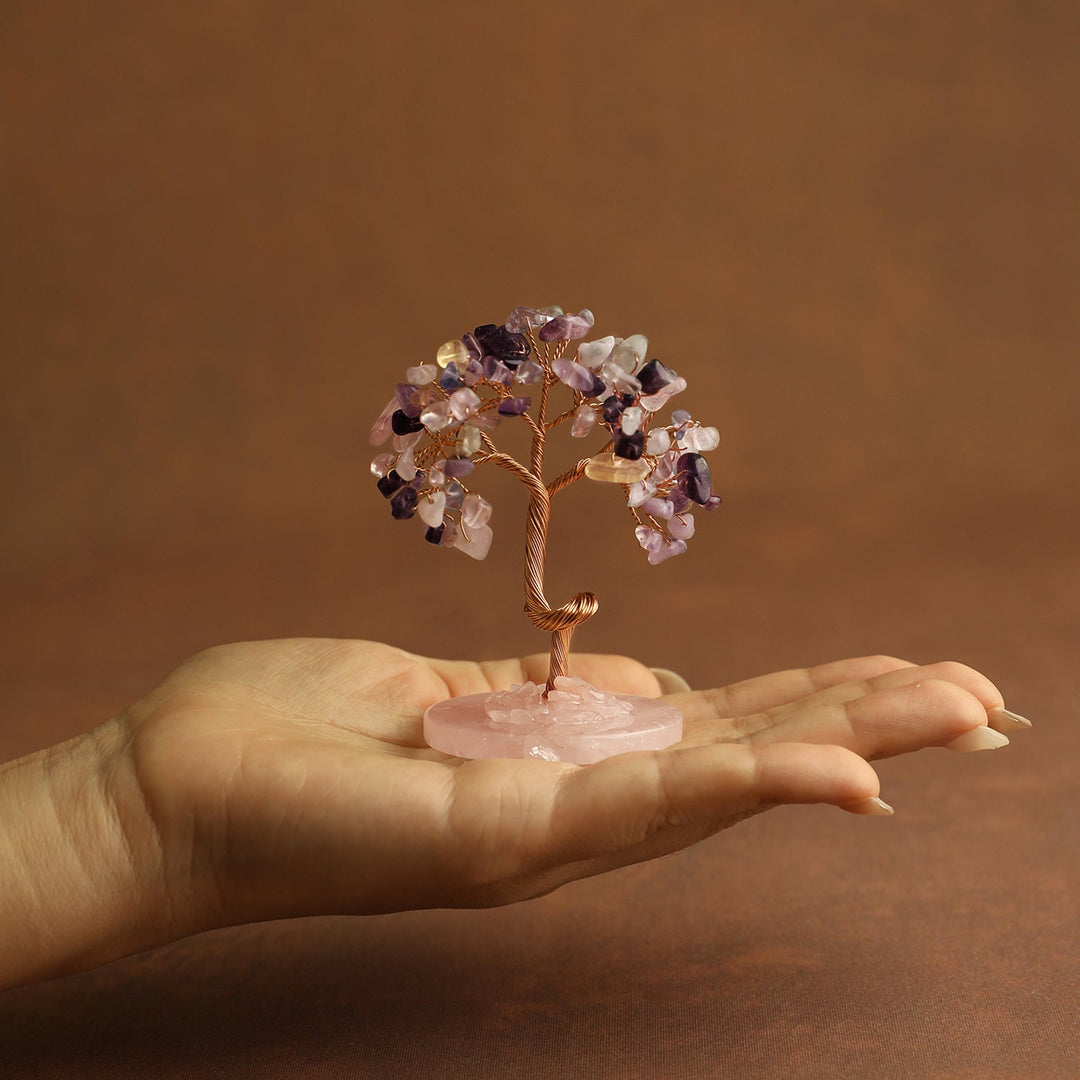 Pink and clear gemstone mini crystal tree on pink stone base, held in hand