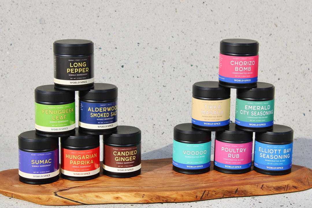 Fines Herbes herb blend among assorted spice jars on a wooden board