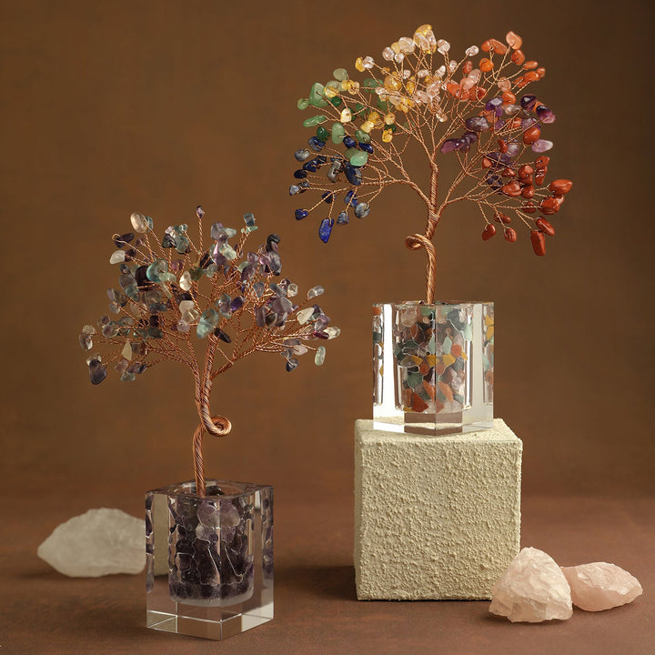 Two gemstone crystal trees with multicolor leaves on cube bases with rocks and stone block