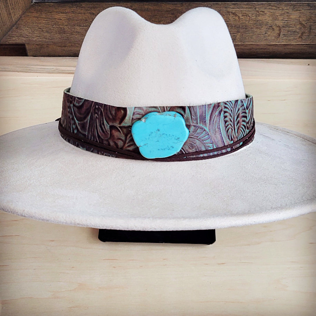 White felt wide-brim hat with brown floral leather band and turquoise emblem