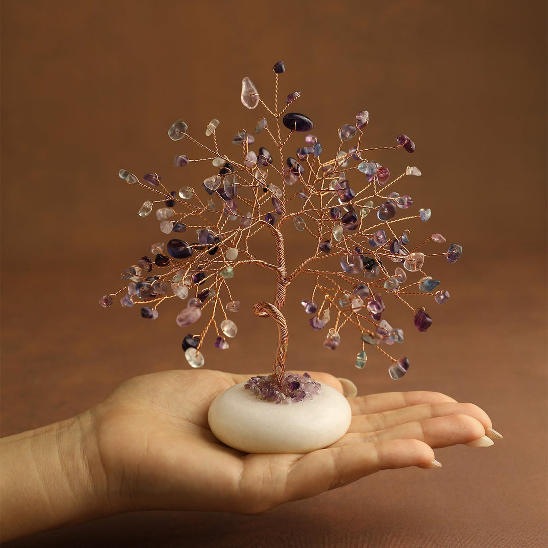 Multicolor gemstone crystal tree on white jade base, hand-held view