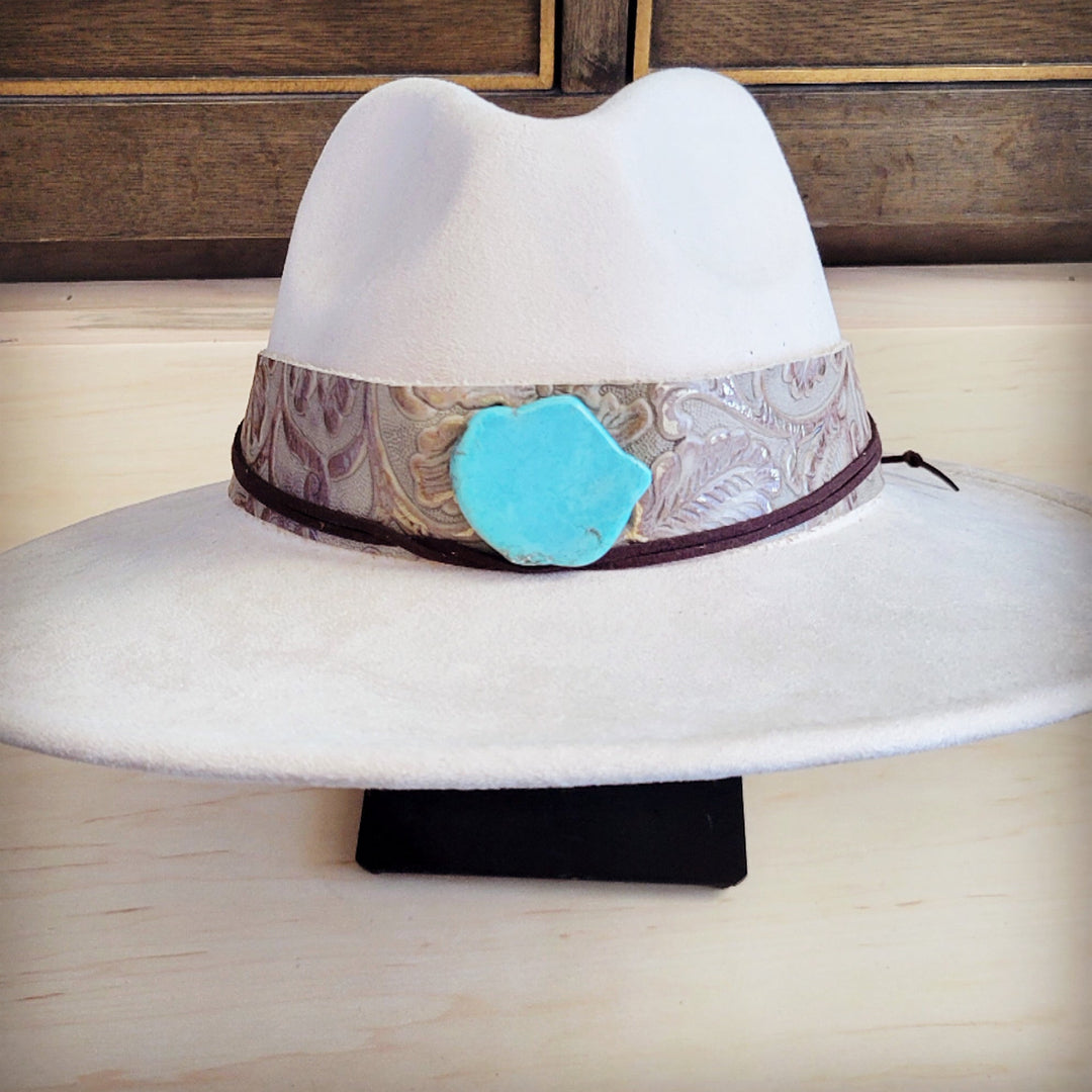 White felt cowboy hat featuring wide patterned leather band with turquoise center