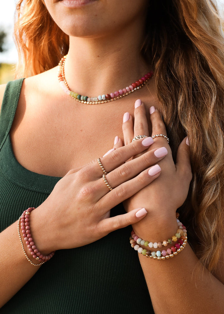 Rainbow bead necklace with gold toggle clasp, layered bracelets