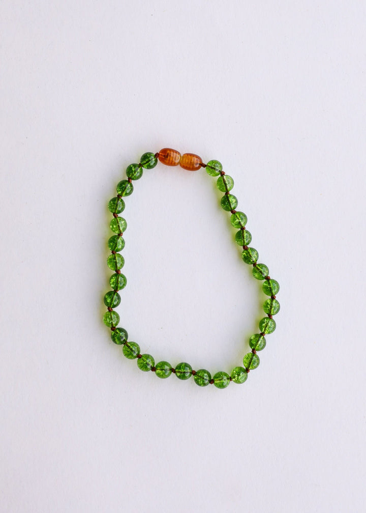 Peridot green gemstone beaded necklace with one amber/golden accent bead at top
