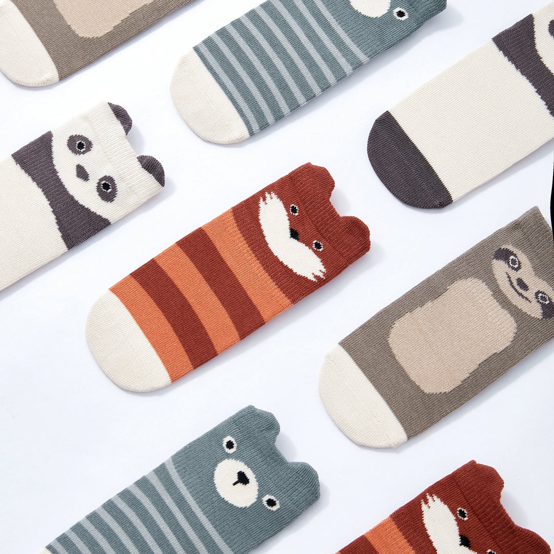 Assorted animal-face and striped non-slip crew socks in cream, tan, teal, and rust