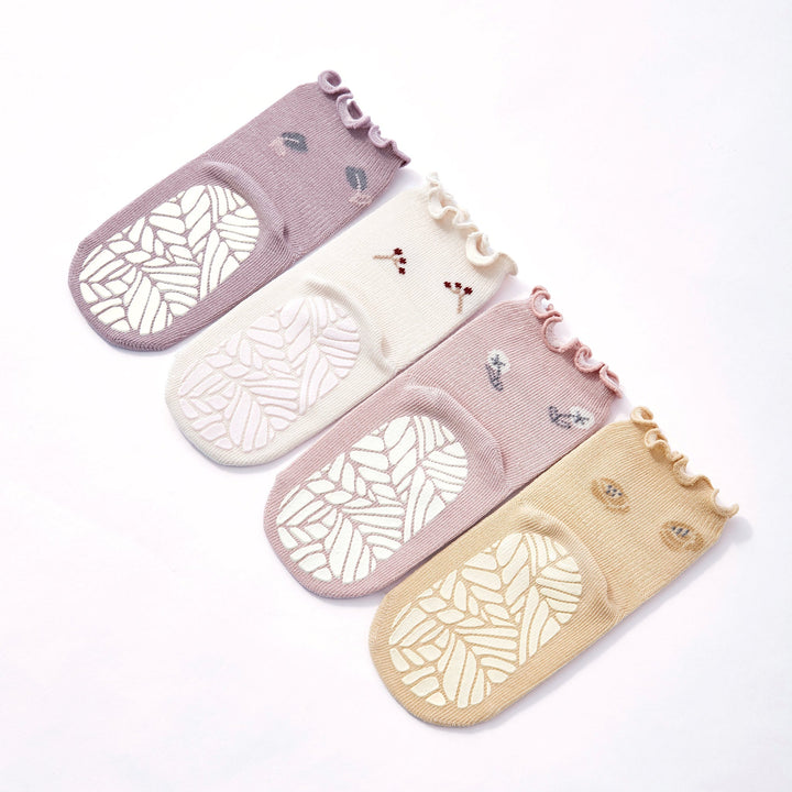 Baby non-slip socks laid flat: lilac, cream, pale pink, and beige pairs with grip soles