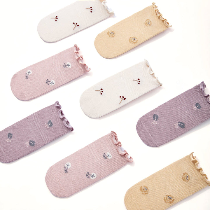 Pastel baby non-slip socks assortment: cream, pale pink, lilac, and beige with ruffled cuffs