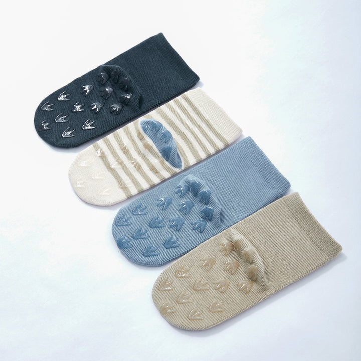 Baby dinosaur crew socks set with paw-print grip soles in navy, blue, and tan