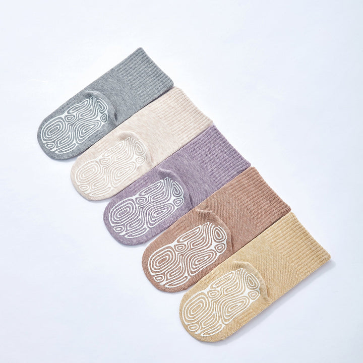 Organic cotton baby socks grouped together: grey, tan, purple, and lemon with patterned soles