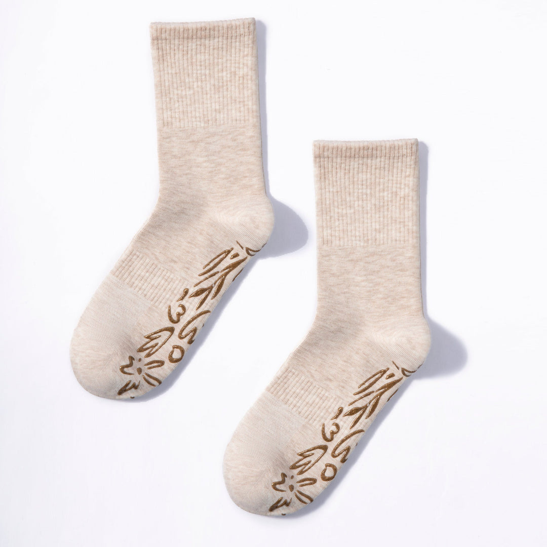 Two beige non-slip grip socks with brown floral pattern on the foot