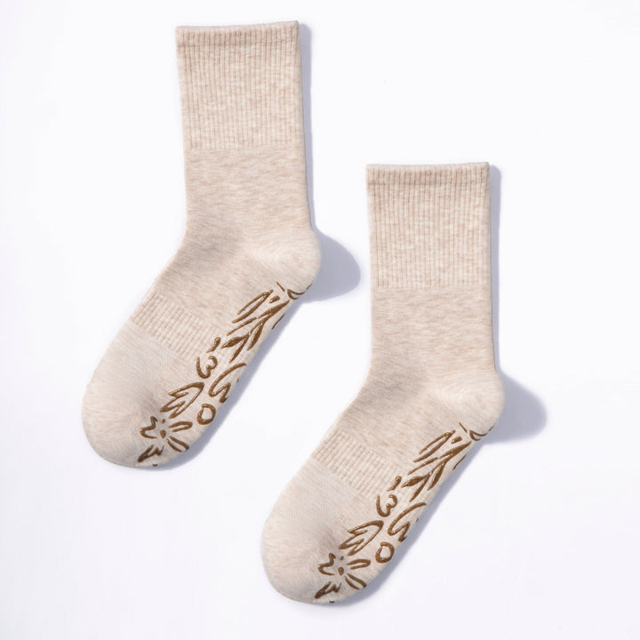 Two beige non-slip grip socks with brown floral pattern on the foot
