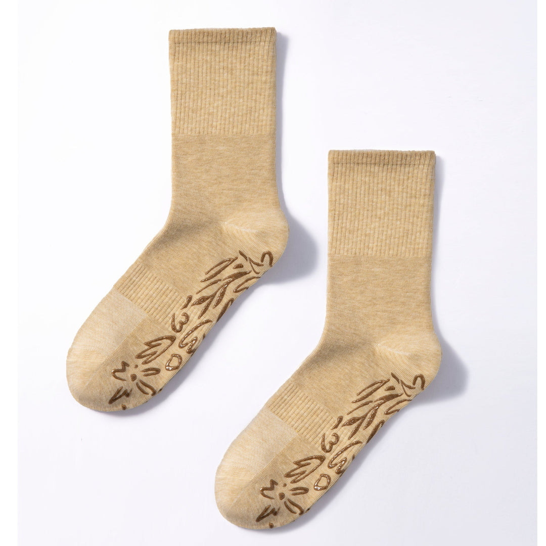 Pair of lemon-beige non-slip socks with brown grip pattern on toe