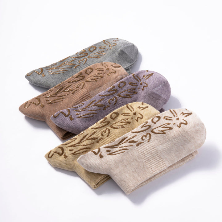 Stack of adult non-slip socks in beige, tan, and gray with floral grip print