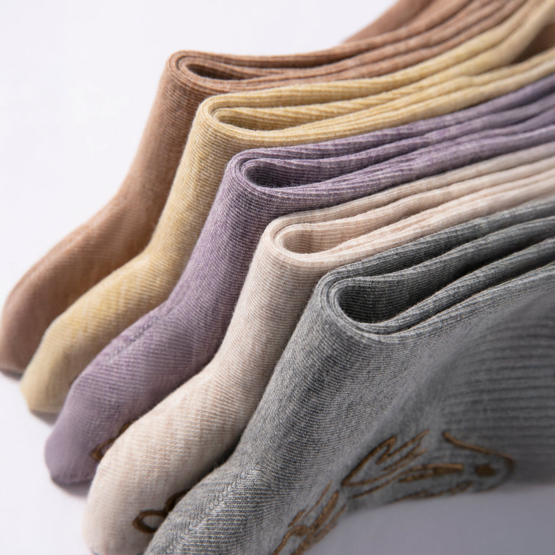 Folded assortment of non-slip socks in multiple neutral shades with grip pattern