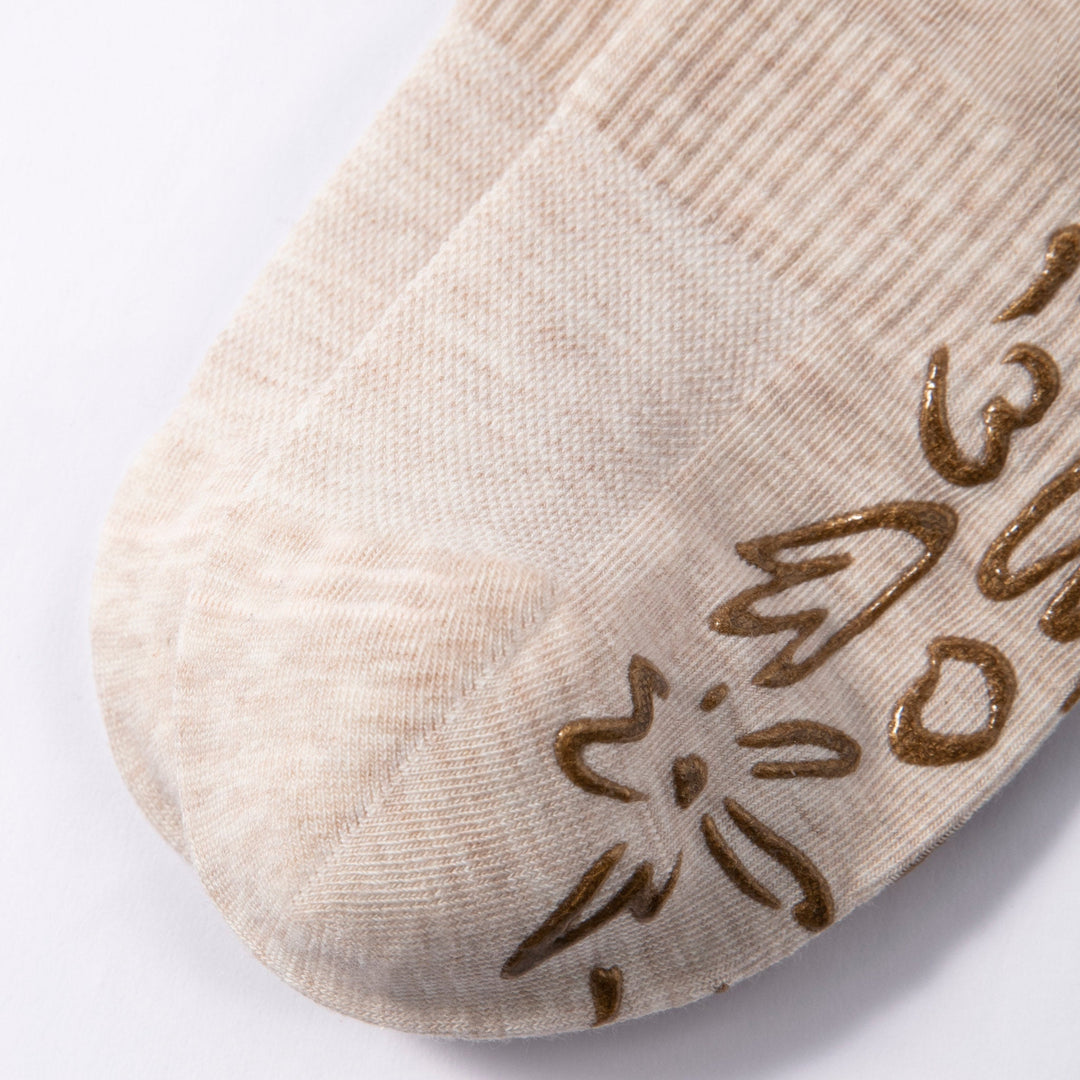 Beige sock toe area with brown floral grip print and textured knit
