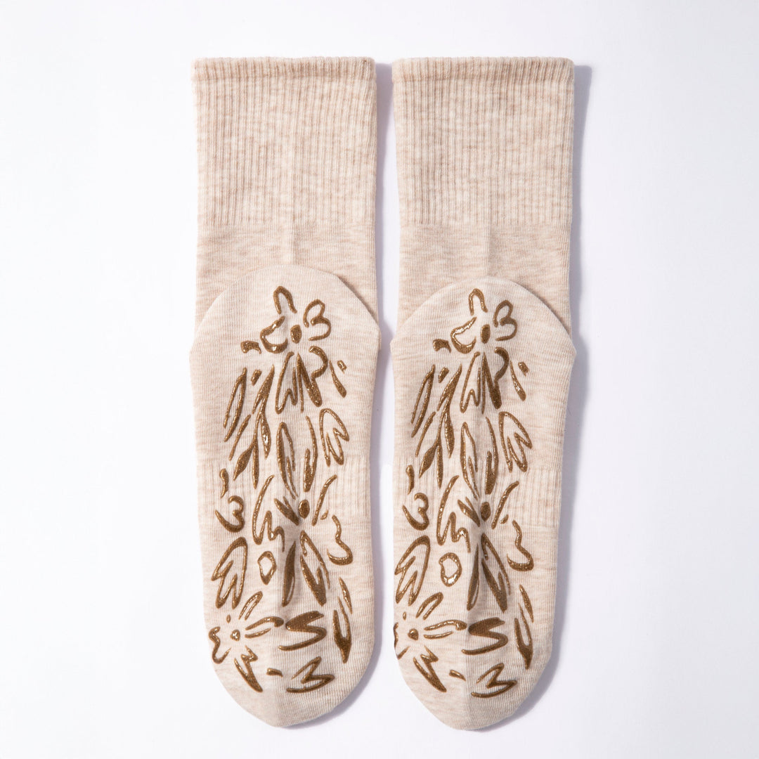 Pair of beige non-slip grip socks with brown floral grip pattern