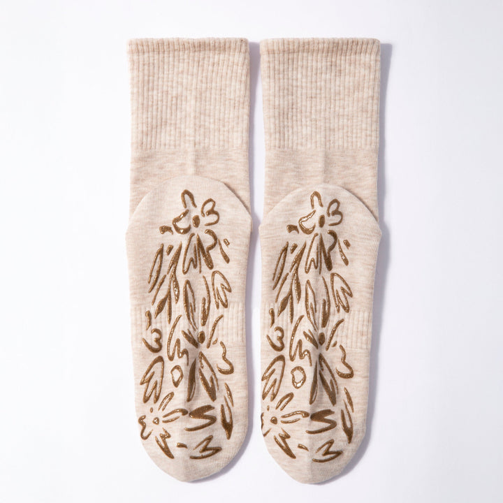 Pair of beige non-slip grip socks with brown floral grip pattern
