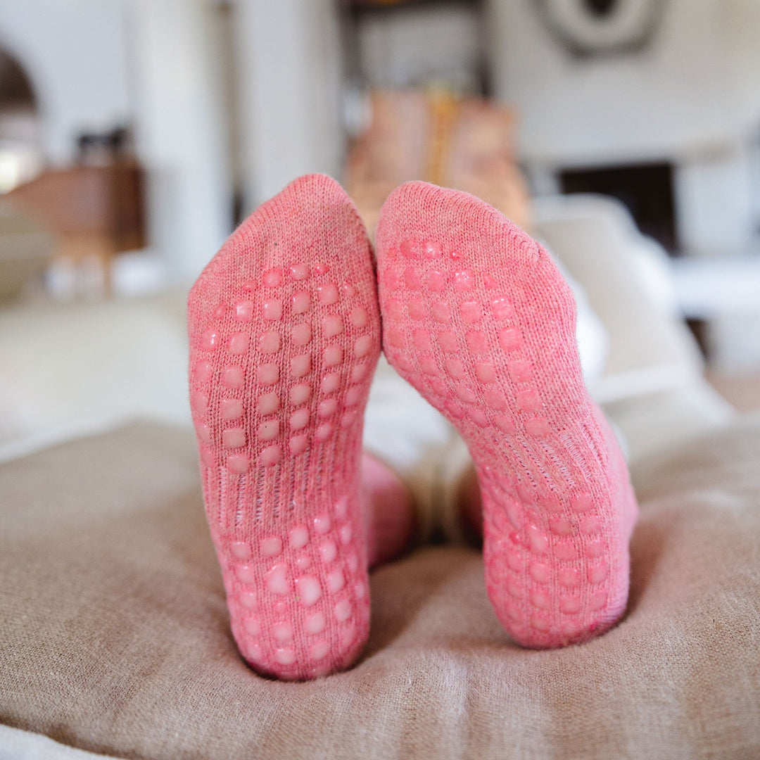 Coral non-slip sock pair with textured grip dots on the sole, folded at the heel