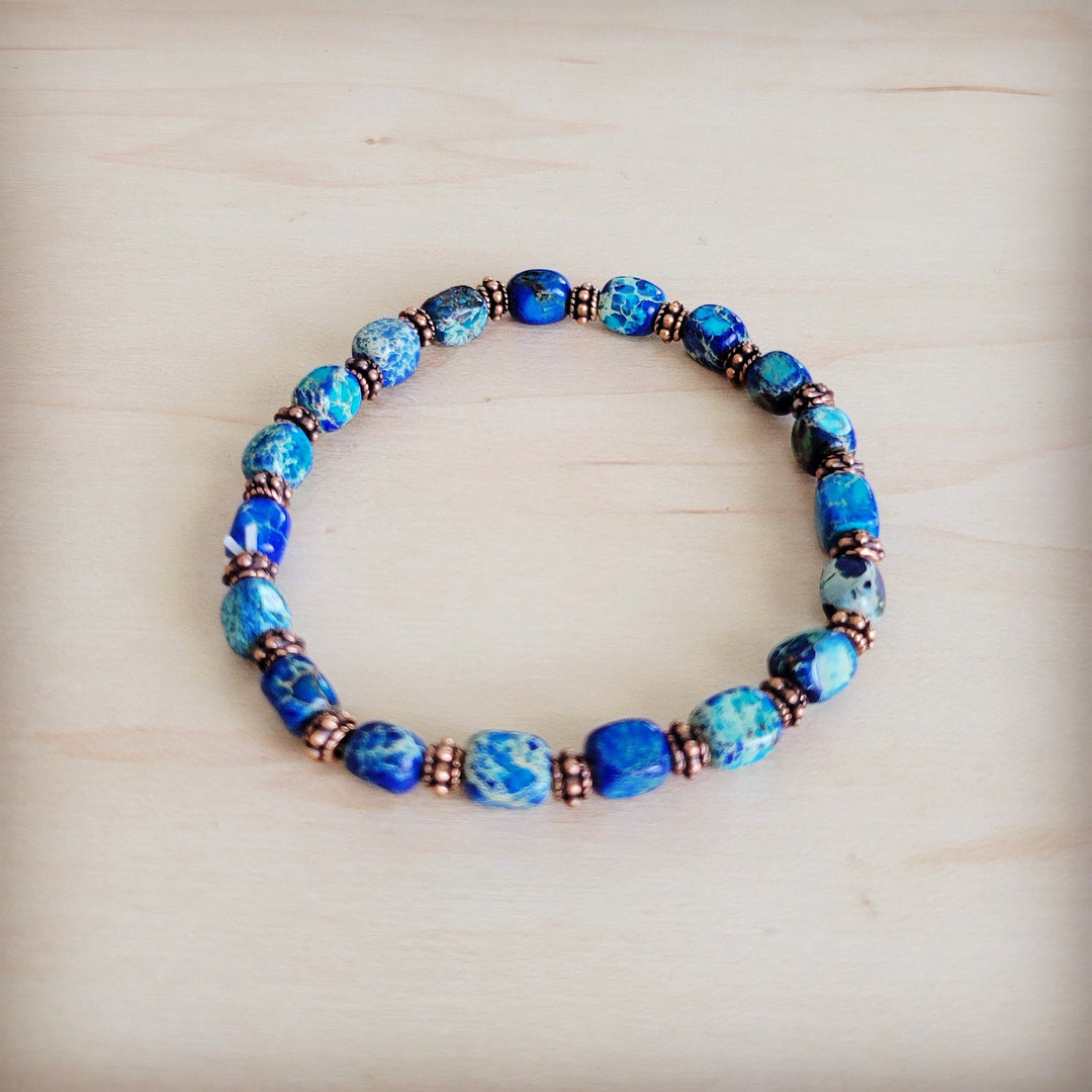 Blue beaded stretch bracelet with copper-toned spacers and round blue stones