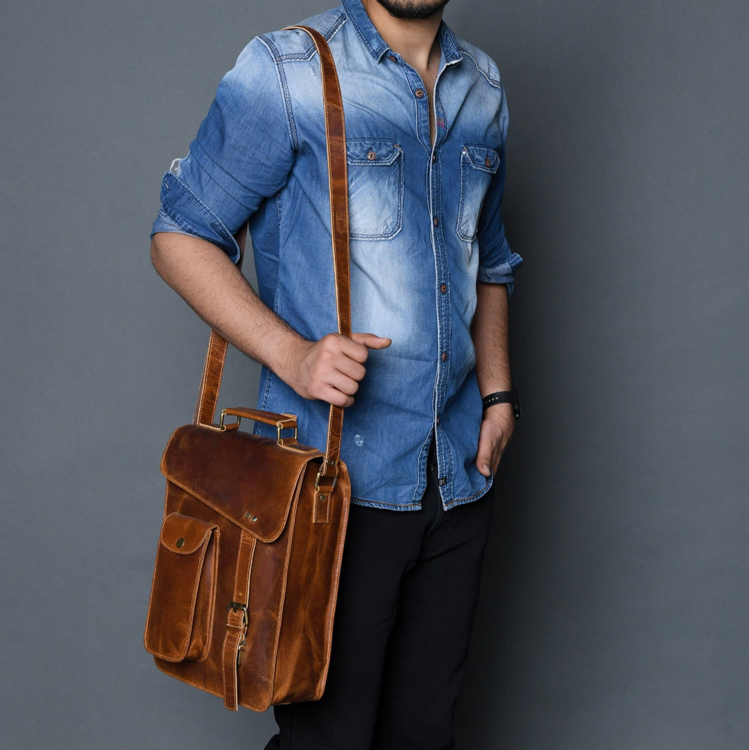 Brown leather crossbody bag worn on shoulder, front flap and two front pockets
