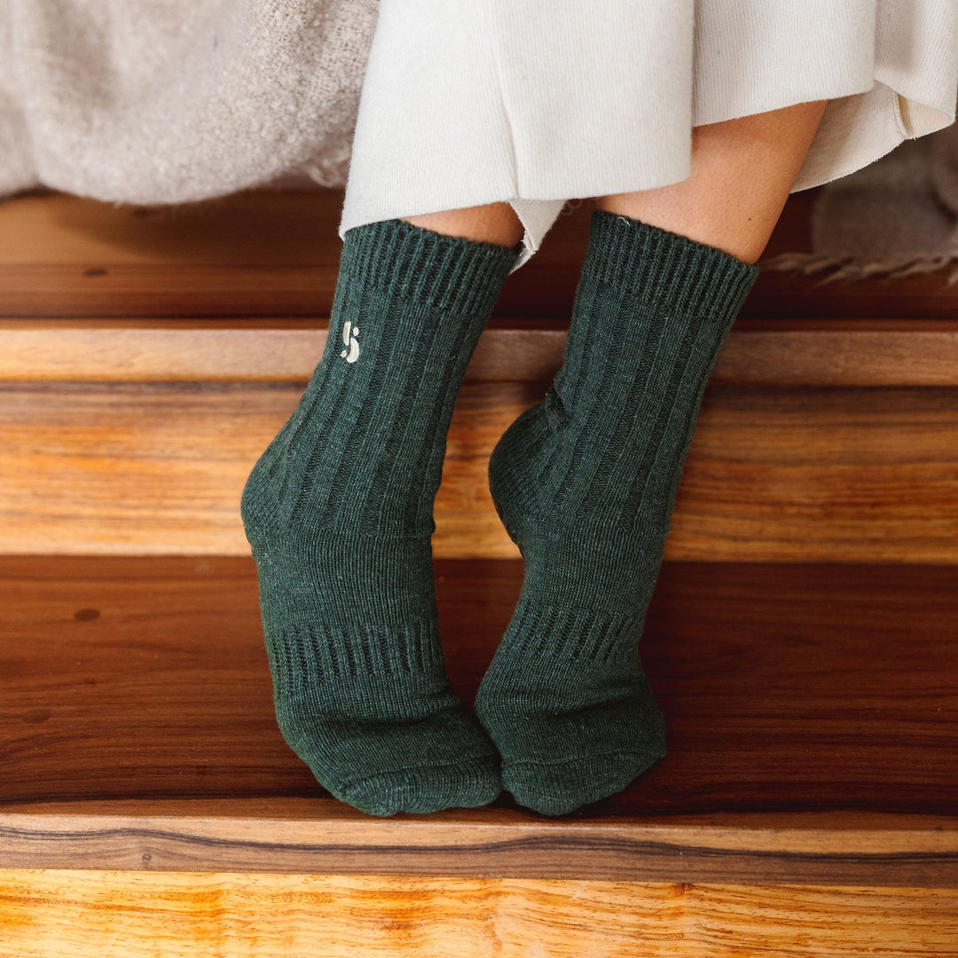 Serene Socks dark green merino wool crew socks on feet, ribbed knit