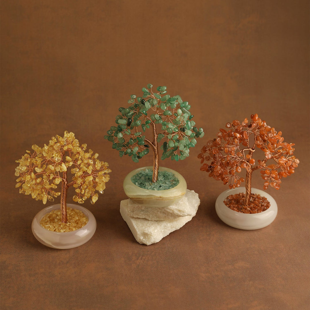 Three multicolor crystal gemstone trees on white oval bases