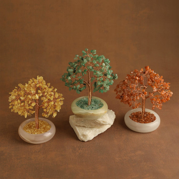 Three multicolor crystal gemstone trees on white oval bases