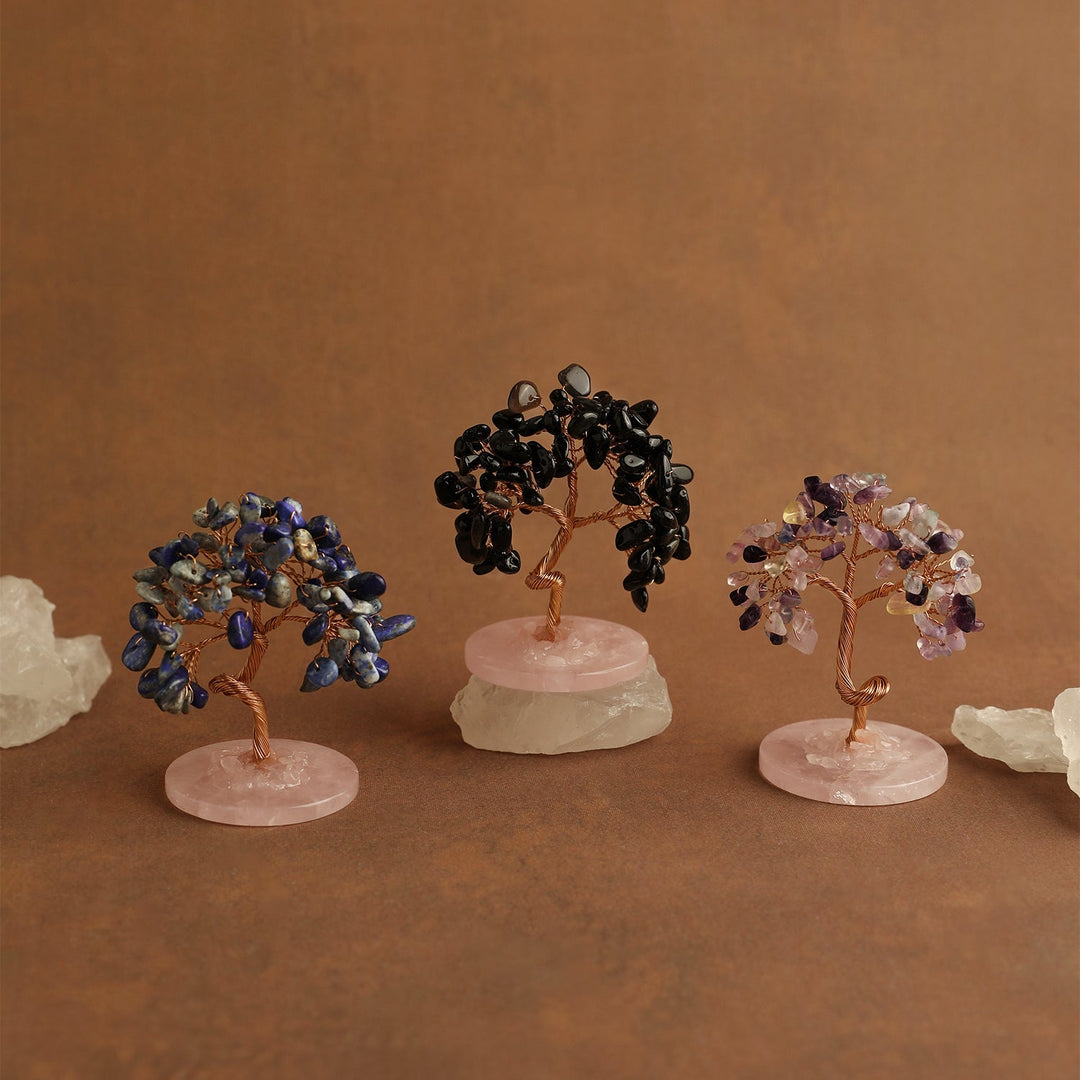 Mini gemstone crystal trees on pale pink bases with dark blue, black, and purple branches