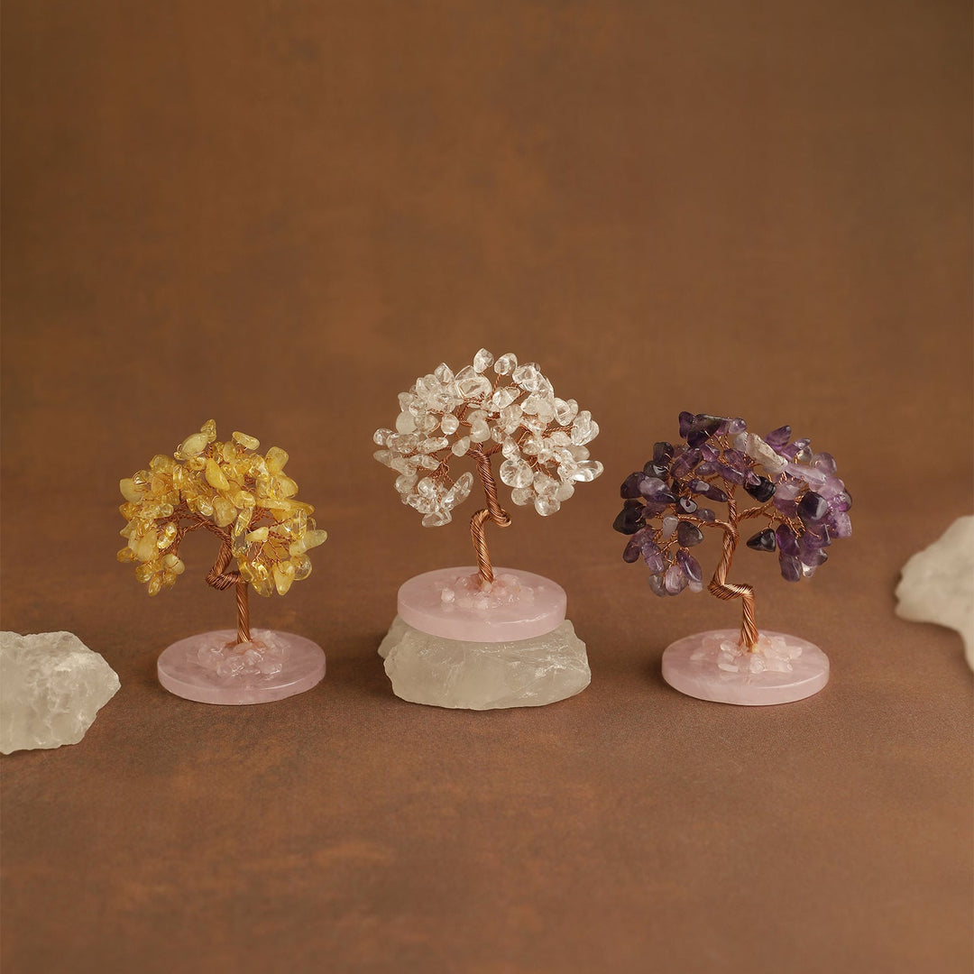 Mini gemstone crystal trees on pale pink bases with clear, gold, and purple stone clusters