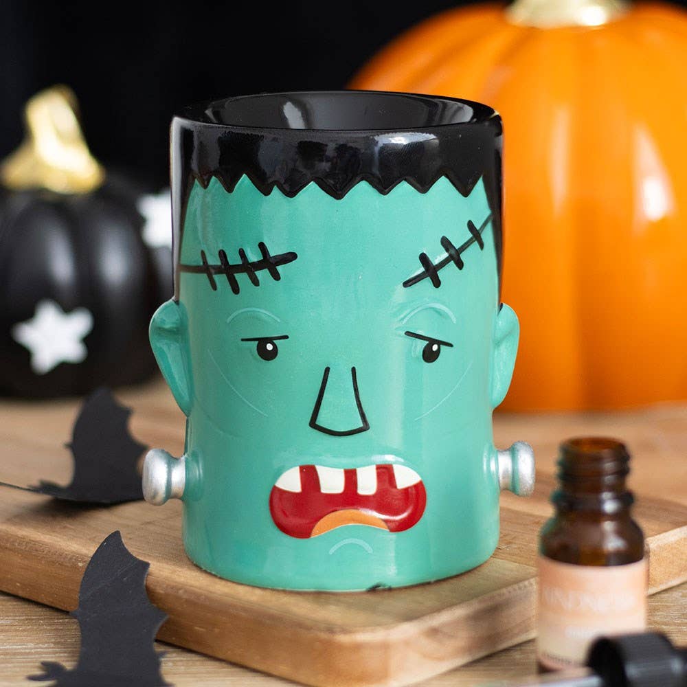 Halloween monster oil burner wax warmer, teal ceramic with black top and stitched face.