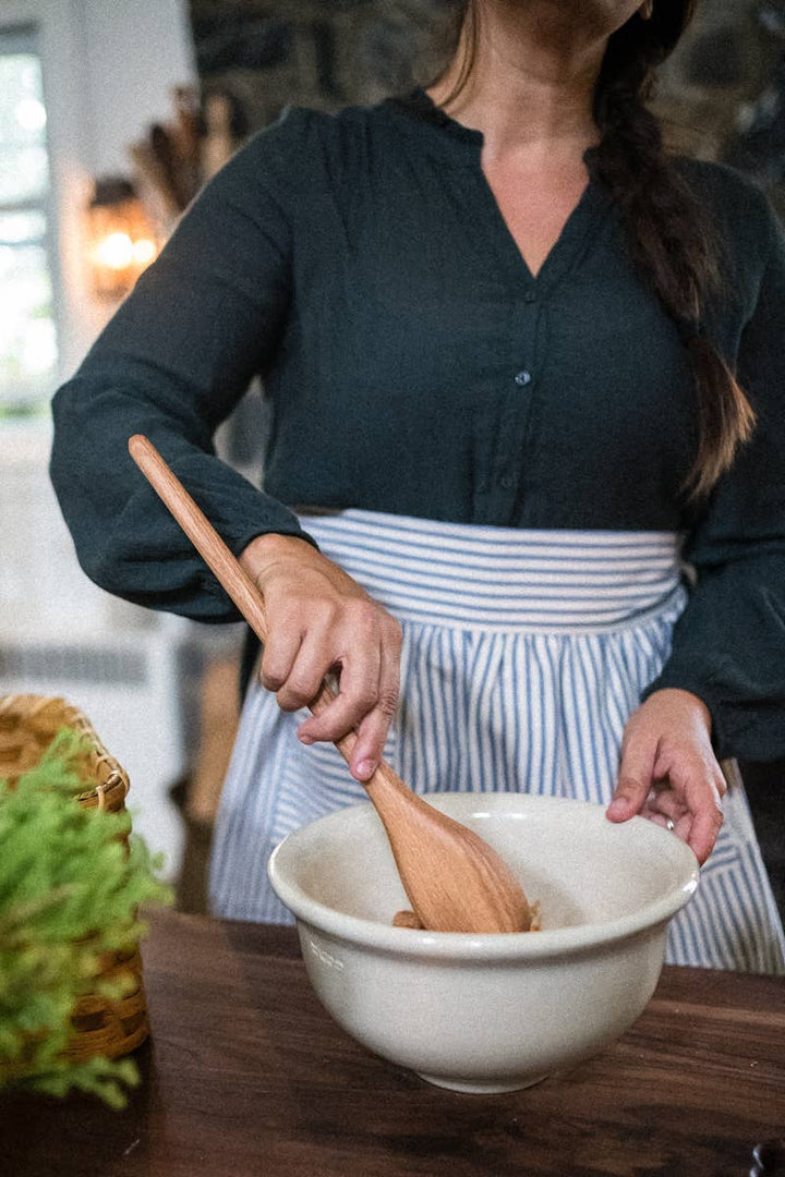 Wooden spoon over a mixing bowl, oval bowl with long handle