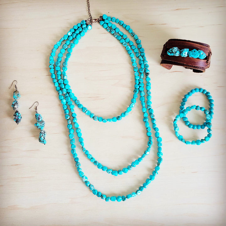 Turquoise beaded stretch bracelet with round beads, photographed with matching set