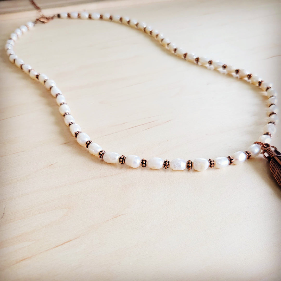 Pearl bead necklace strand with copper accents and feather tassel end