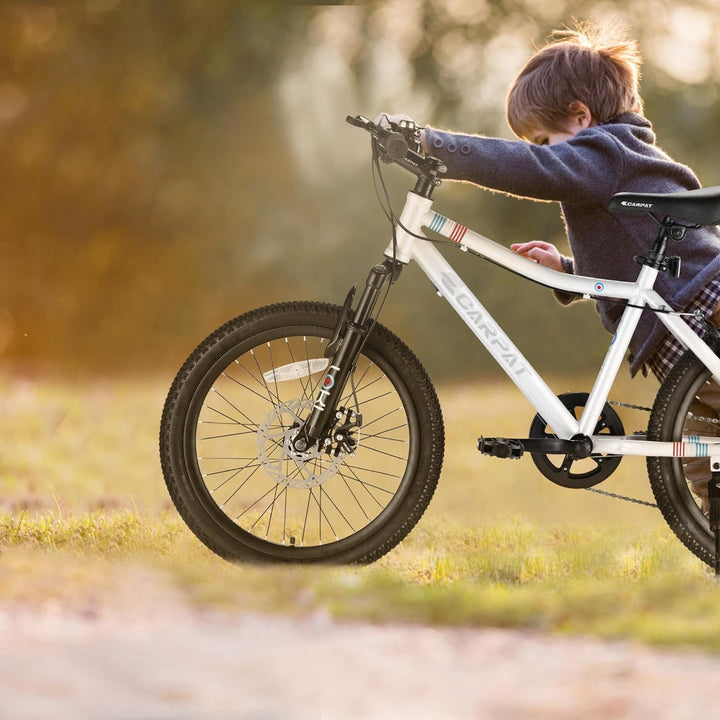 Child riding a kids 20-inch mountain bike with front suspension and knobby tires