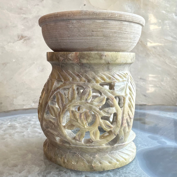 Carved soapstone essential oil burner with circular cutout and leaf relief pattern