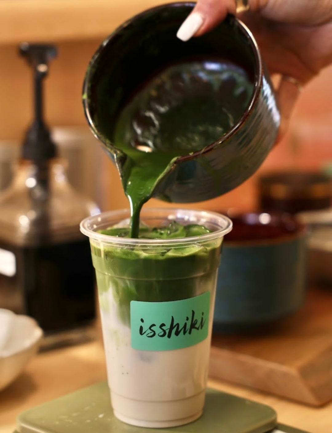 Single-cultivar matcha being poured into a clear takeaway cup