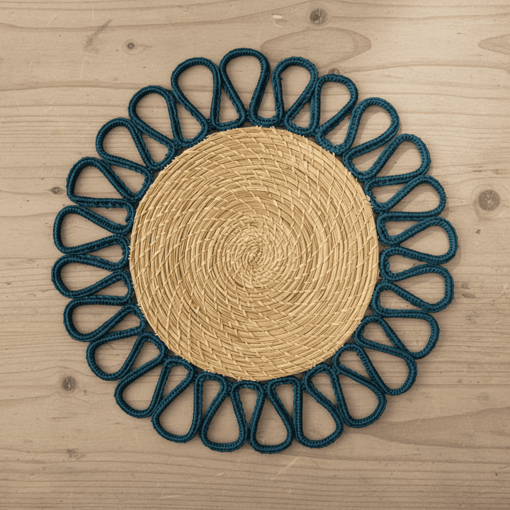 Round handwoven iraca placemat with orange loop trim and tan woven center