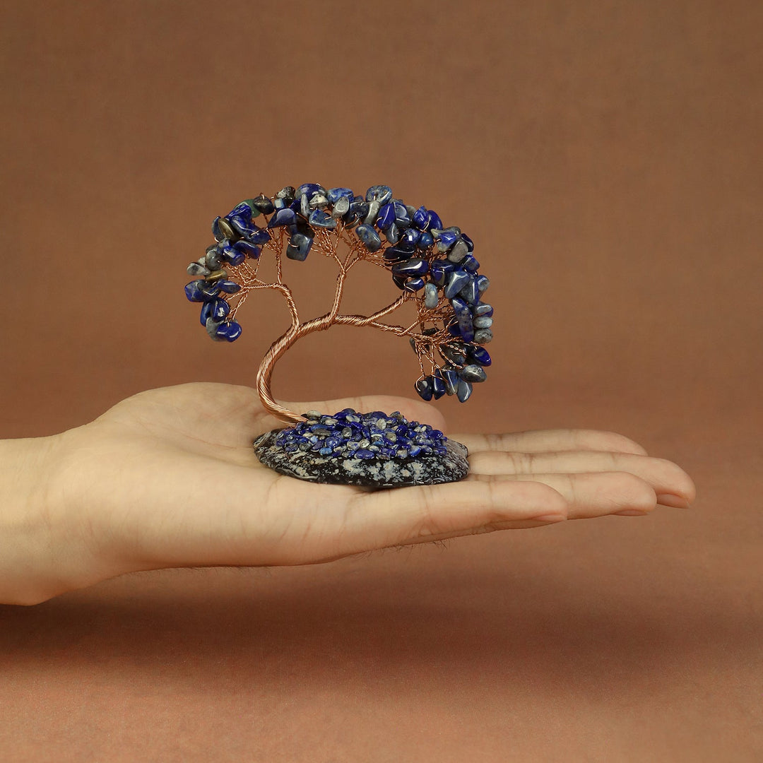 Blue crystal tree ornament with copper wire trunk and beaded stones on a base.